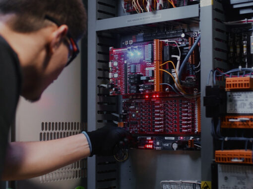 A focused technician troubleshooting an elevator's red control board with LED indicators.