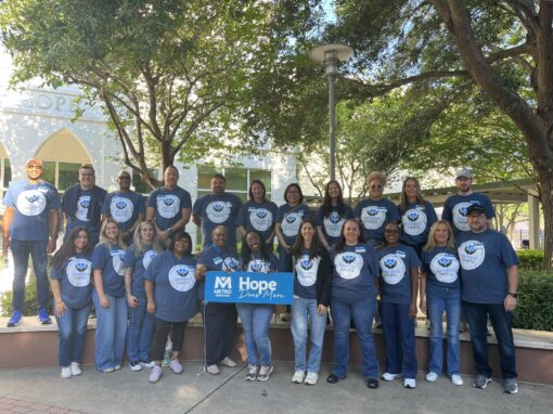 Elevated Facility Services employees pose together outside Metropolitan Ministries wearing Elevated Hearts shirts.